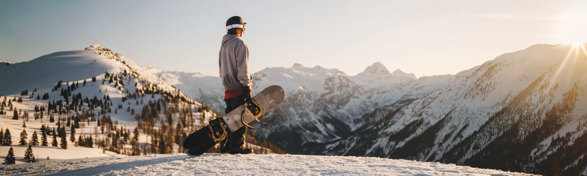 Skinnies About Us hero — snowboarder in the mountains