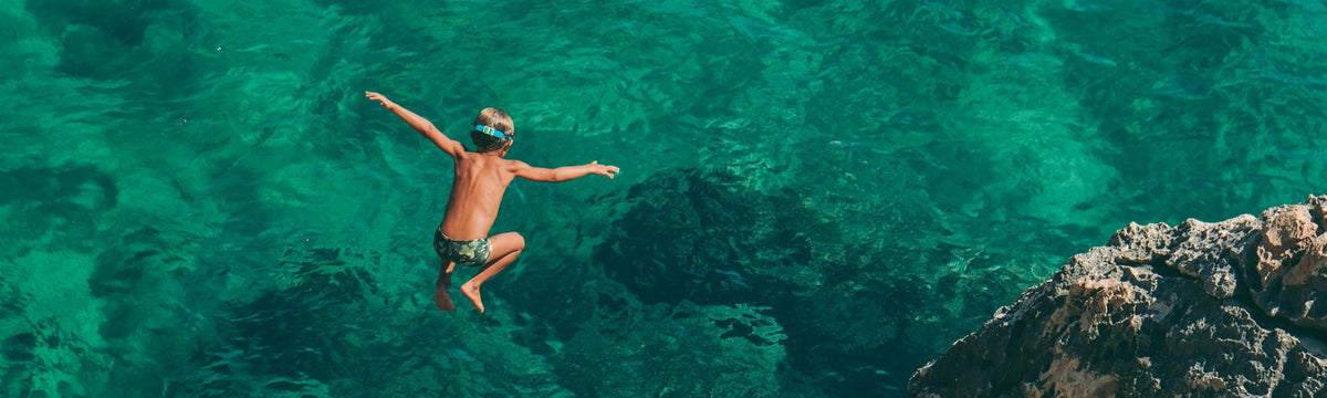 Kid jumping into turquoise water